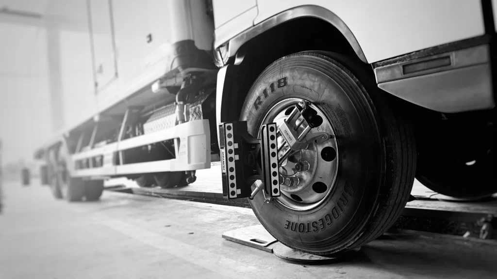 A commercial truck steer tire fitted with a Hunter Engineering wheel alignment target sensor during a professional fleet alignment inspection to correct irregular tread wear.