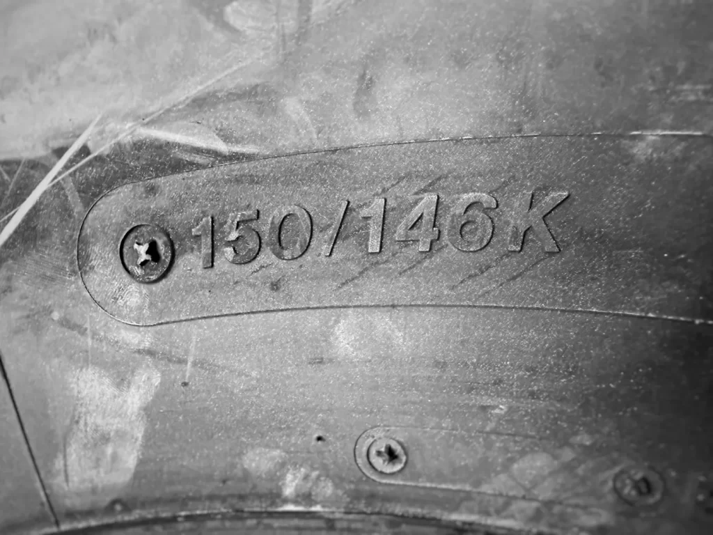 Close-up of truck tire sidewall showing 150/146K load index and speed rating symbol.