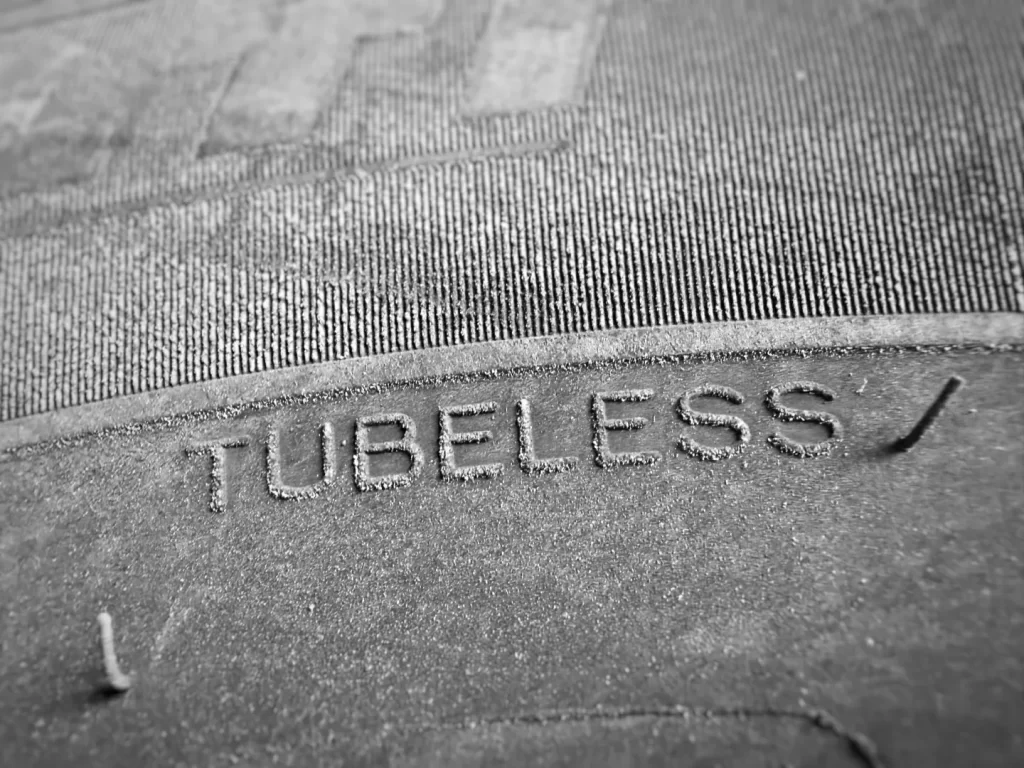 Close-up of TUBELESS marking stamped on a commercial truck tire sidewall.